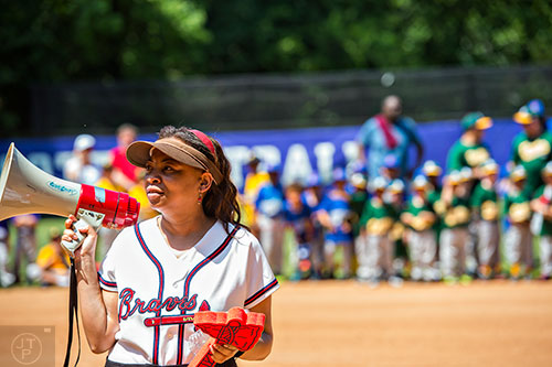 Keisha Cunningham (left) talks to teams using a bullhorn during the ceremony for the opening day of Decatur Youth Baseball at Oakhurst Park on Saturday, June 6, 2015.