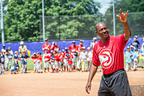 Mike Glenn (right), a former Atlanta Hawks player, walks out onto the field during the ceremony for the opening day of Decatur Youth Baseball at Oakhurst Park on Saturday, June 6, 2015.
