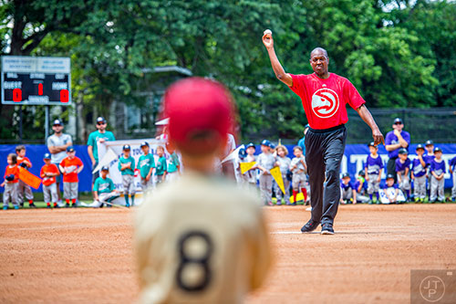 Mike Glenn (right), a former Atlanta Hawks player, throws out the opening pitch during the ceremony for the opening day of Decatur Youth Baseball at Oakhurst Park on Saturday, June 6, 2015.