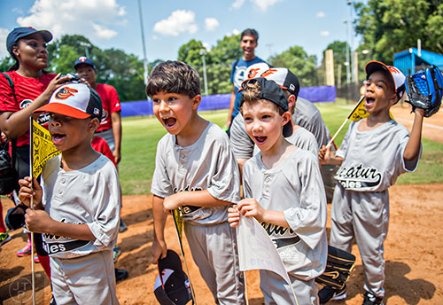 Aidan Knapp (center left) and his team cheer as the ceremony for the opening day of Decatur Youth Baseball comes to a close at Oakhurst Park on Saturday, June 6, 2015.
