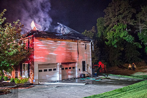 Gwinnett County firefighters extinguish a fire at 805 Hiram Davis Rd. in Lawrenceville on Wednesday, June 17, 2015.