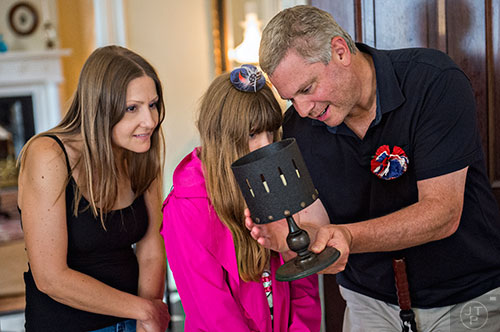 Julie Link (left), Caroline March and her father Aaron check out a zoetrope while on a tour during the inaugural BBQ & Bluegrass at Barrington Hall in Roswell on Saturday, July 4, 2015. 
