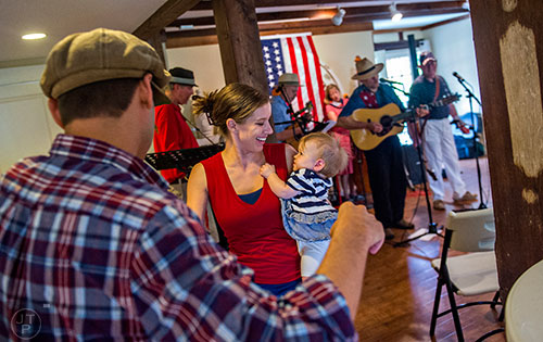 Katie Hawn (center) dances holds her daughter Celestine as she dances with her husband Trevor during the inaugural BBQ & Bluegrass at Barrington Hall in Roswell on Saturday, July 4, 2015. 