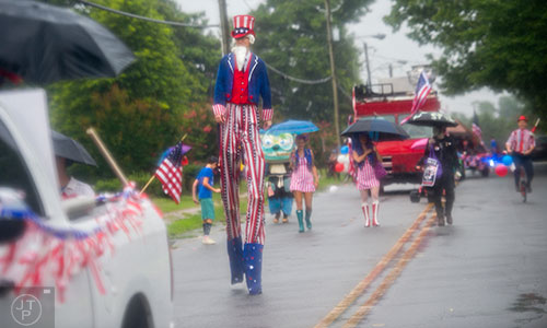 Uncle Sam marches on stilts down Clarendon Ave. in the pouring rain during the Avondale Estates 4th of July Parade on Saturday, July 4, 2015. 