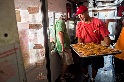 Todd Kazenske (right) carries a tray of pies inside the That Pie Place food truck during the Atlanta Street Food Festival at Piedmont Park in Atlanta on Saturday, July 11, 2015. 