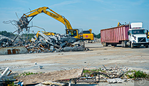 An excavator fills a semi truck with scrap metal that will be hauled off to a recycling center at the GM Plant in Doraville on Monday, June 29, 2015.