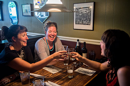 Patrons enjoy a toast and a glass of wine during Eat Me Speak Me at Gato off of McLendon Ave. in Atlanta on Friday, July 3, 2015.
