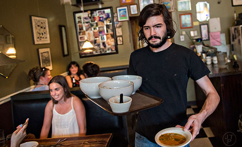 Gage Gilmore (right) takes a tray of food to a table during Eat Me Speak Me at Gato off of McLendon Ave. in Atlanta on Friday, July 3, 2015.
