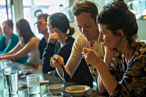 Patrons try the heirloom tomato type soup with shiso oil, nori, seasame and scallion during Eat Me Speak Me at Gato off of McLendon Ave. in Atlanta on Friday, July 3, 2015.