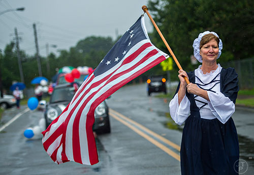 Betsy Ross marches down Clarendon Ave. in the pouring rain during the Avondale Estates 4th of July Parade on Saturday, July 4, 2015.  