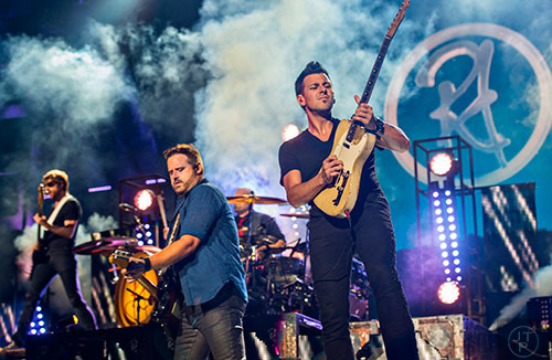 Justin Butler (right) performs on stage with Randy Houser (center) at Philips Arena in Atlanta on Friday, August 21, 2015. 