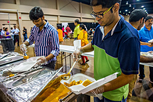 Rakesh Devarala (right) and Siva Kilaru serve up authentic Indian food during the Festival of India at the Gwinnett Center in Duluth on Saturday, August 22, 2015.