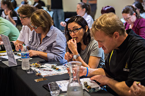 Diana Leal (center) tastes one of the entries in the Chocolatier of the Year competition during Pastry Live 5 at 200 Peachtree in Atlanta on Sunday, August 23, 2015. 