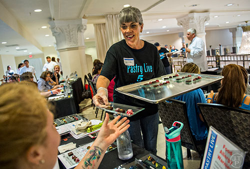 Janice Baskin (center) hands out trays of chocolates as a part of the Chocolatier of the Year competition during Pastry Live 5 at 200 Peachtree in Atlanta on Sunday, August 23, 2015. 