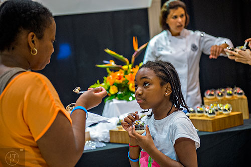 Grace Fairley (center) and her mother Christina taste sweets created by Analia Bobber, pastry chef at the Druid Hills Golf Club, during Pastry Live 5 at 200 Peachtree in Atlanta on Sunday, August 23, 2015. 