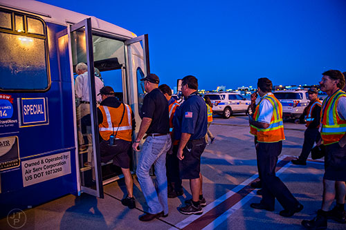 Around 100 airport employees load up onto buses to take them to runway 8L/26R at Hartsfield Jackson Atlanta International Airport during the 14th annual FOD Walk on Wednesday, August 26, 2015.     