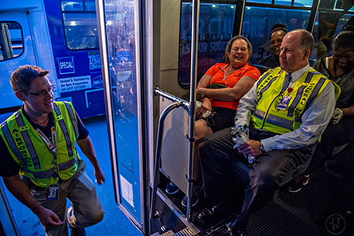 Taylor Andrews (left) boards a bus with Pat Armes and Greg Richardson to take them to runway 8L/26R at Hartsfield Jackson Atlanta International Airport during the 14th annual FOD Walk on Wednesday, August 26, 2015. 