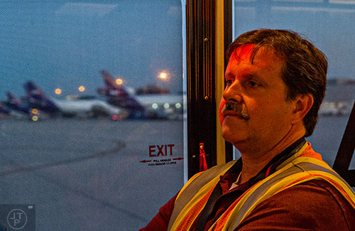 Brad Ellis rides a bus to take him to runway 8L/26R at Hartsfield Jackson Atlanta International Airport during the 14th annual FOD Walk on Wednesday, August 26, 2015. 
