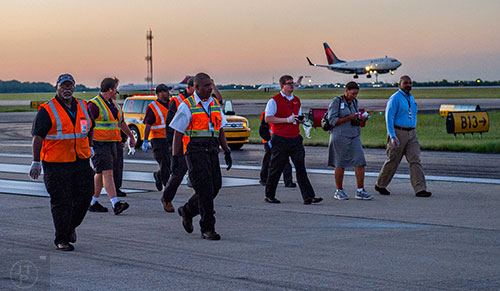 Around 100 airport employees walk down runway 8L/26R at Hartsfield Jackson Atlanta International Airport looking for foreign object debris during the 14th annual FOD Walk on Wednesday, August 26, 2015. 