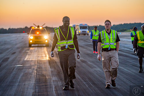 Steven Bien-Aime (left) and Taylor Andrews look for foreign object debris as they walk down runway 8L/26R at Hartsfield Jackson Atlanta International Airport during the 14th annual FOD Walk on Wednesday, August 26, 2015. 