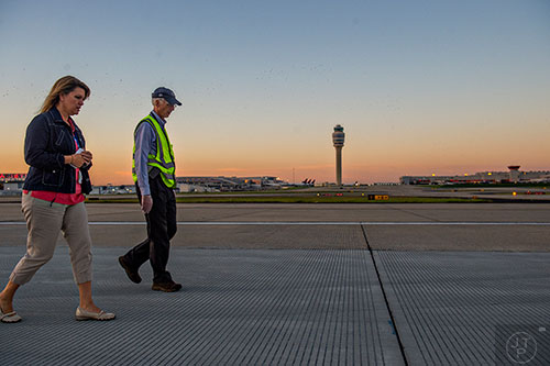 Jaimi Tapp (left) and Jim Drinkard look for foreign object debris as they walk down runway 8L/26R at Hartsfield Jackson Atlanta International Airport during the 14th annual FOD Walk on Wednesday, August 26, 2015.