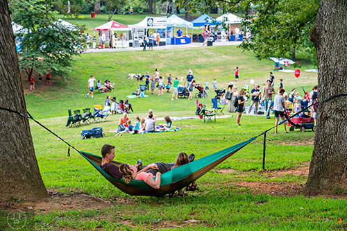 Trace Burks (left), Michelle Krengel and Scarlett Burks lay in a hammock listening to music during the 13th annual Grant Park Summer Shade Festival on Saturday, August 29, 2015. 