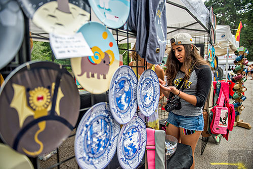 Avery Freiman (center) chooses a few piece of art at Sarah Marks' booth  during the 13th annual Grant Park Summer Shade Festival on Saturday, August 29, 2015. 