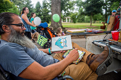 Jim Straehla paints at his booth as people pass by during the 13th annual Grant Park Summer Shade Festival on Saturday, August 29, 2015.