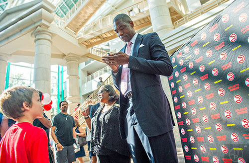 Dikembe Mutombo (right) signs an autograph for Owen Ginsburg after the celebration naming September 1 as Dikembe Mutombo Day in Fulton County at the Fulton County Government Center in Atlanta on Tuesday, September 1, 2015.   