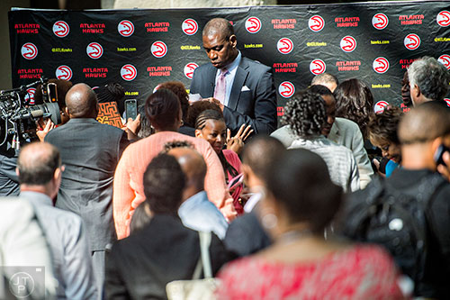 Dikembe Mutombo (center) signs autographs after the celebration naming September 1 as Dikembe Mutombo Day in Fulton County at the Fulton County Government Center in Atlanta on Tuesday, September 1, 2015.   