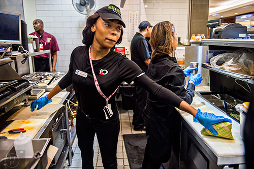Shanterika Shealey (center) passes a finished sandwich to her coworker in cramped quarters on the line of Fresh to Order at the Hartsfield Jackson Atlanta International Airport on Wednesday, September 2, 2015. 