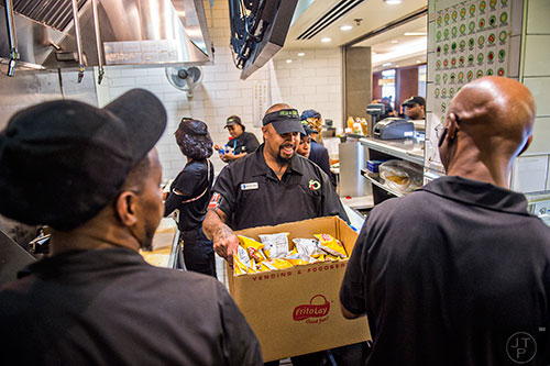 Shawn Zellner (center) restocks bags of chips at Fresh to Order inside the Hartsfield Jackson Atlanta International Airport on Wednesday, September 2, 2015. 