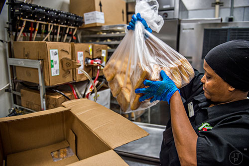 Lula Omer unpacks bread in cramped quarters in the kitchen of Fresh to Order at the Hartsfield Jackson Atlanta International Airport on Wednesday, September 2, 2015. 