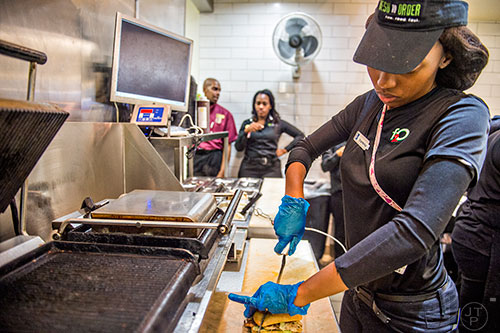 Shanterika Shealey uses a tethered knife to cut a sandwich at Fresh to Order inside the Hartsfield Jackson Atlanta International Airport on Wednesday, September 2, 2015. 