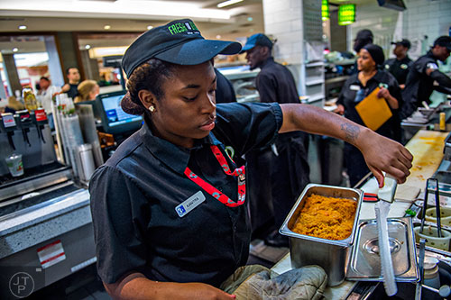 Kanitra Williams (left) uses a tethered knife at Fresh to Order inside the Hartsfield Jackson Atlanta International Airport on Wednesday, September 2, 2015. 