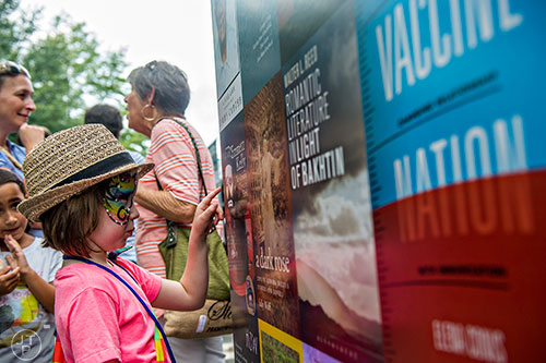 Annie Marquardt sounds out the titles of books on a poster during the AJC Decatur Book Festival on Saturday, September 5, 2015. 