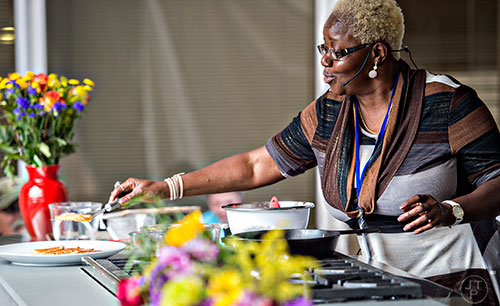 Dora Charles lays some fried cornbread, or hoecakes as she grew up calling them, on a plate during the AJC Decatur Book Festival on Saturday, September 5, 2015. 