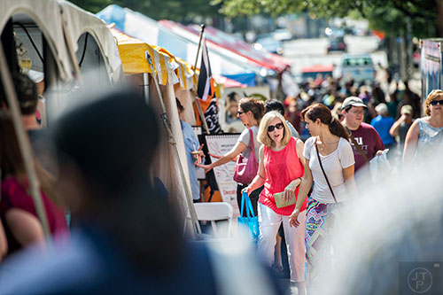 Debbie Todd (center left) and Daniela Todd walk past tents upon tents of books during the AJC Decatur Book Festival on Saturday, September 5, 2015. 