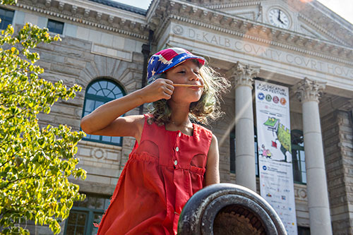Sascha Blanchford finishes her popsicle while sitting on the cannon outside of the Historic Dekalb County Courthouse during the Decatur Book Festival on Saturday. 