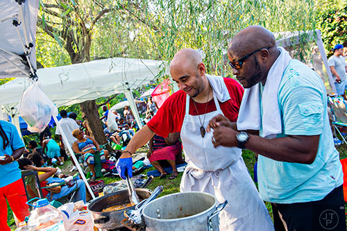 Emanuel Thompson (left) and Malik Jones cook food during House at the Park at Grant Park in Atlanta on Sunday, September 6, 2015.