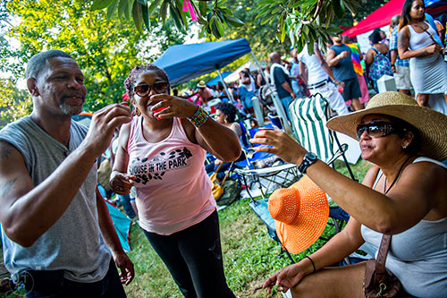 Tracy Gilmore (left), Joanne Hunt and her sister Wendy take a shot of tequilla during House at the Park at Grant Park in Atlanta on Sunday, September 6, 2015.