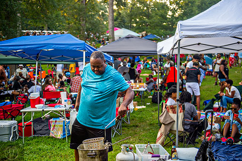 Kenneth Jones (center) checks on his chicken wings and rib tips during House at the Park at Grant Park in Atlanta on Sunday, September 6, 2015.