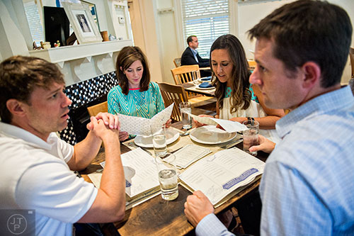 Tiish Shirley (left) and Mindy Abercrombie look over their menus as their husbands Bobby and Matt (respectively) talk at Revival in Decatur.