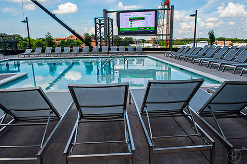 A view of the outside courtyard and pool with views of downtown at University House in Atlanta also features a 16x9, that's in feet, jumbotron television.