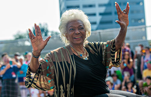 Nichelle Nichols, who played communications officer Lieutenant Uhura aboard the USS Enterprise in the popular Star Trek television series and succeeding motion pictures, gives the Vulcan symbol of live long and prosper as she rides down Peachtree St. during the annual DragonCon Parade in Atlanta on Saturday, September 5, 2015.  