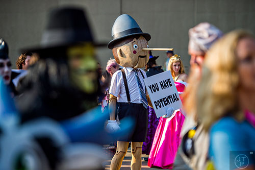 Dressed as Pinocchio, Bill Williams holds his sign as he waits in the marshalling yard for the start of the annual DragonCon Parade in Atlanta on Saturday, September 5, 2015.   