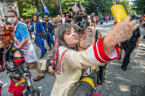 Jessica Gwinette (center) takes a selfie with Joshua Bohn as he marches down Peachtree St. during the annual DragonCon Parade in Atlanta on Saturday, September 5, 2015.   