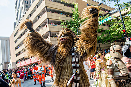 Dressed as Chewbacca, Matt Pfingsten throws his hands into the air during the annual DragonCon Parade in Atlanta on Saturday, September 5, 2015.   