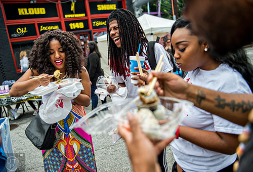 Taylor Malone (left), Jeremy Garner and Rakiya Johnson eat sushi in the street during the 5 Arts Fest in the Little Five Points neighborhood of Atlanta on Saturday, September 12, 2015.