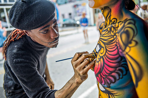 Artist Rio Sirah (left) puts the finishing details on a model's body during the 5 Arts Fest in the Little Five Points neighborhood of Atlanta on Saturday, September 12, 2015. 